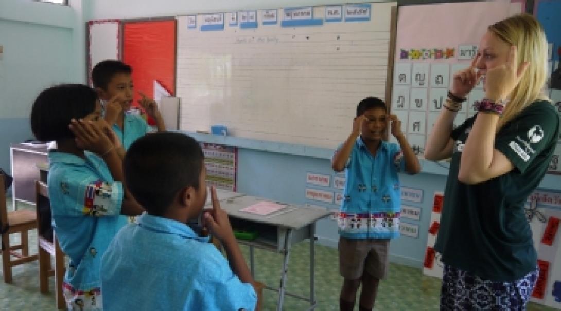 Volunteer gains teaching work experience in Thailand while teaching her students the English words for different body parts. A Projects Abroad volunteer teaches her students head shoulders knees and toes when she volunteers as an English teacher in Thailand.